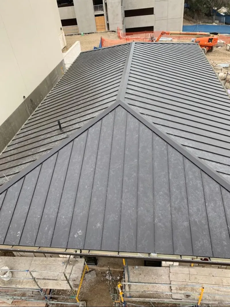 Commercial metal roof construction with crane equipment in Collinsville